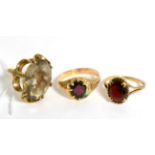 A 9ct gold citrine dress ring, finger size J and two 9ct gold garnet rings (3)11g gross