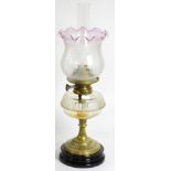 A Victorian oil lamp with clear glass reservoir and etched glass shade