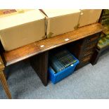 An early 20th century oak desk of small proportions with four drawers and drop leaf