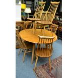 An Ercol light oak drop leaf table and six chairs