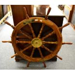 A ten spoke ships wheel, bearing plaque ''H.M.S. GALATEA 1951-78''
