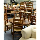 A set of six oak framed ladder back dining chairs with rush seats with matching circular dining