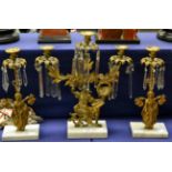 A three piece gilt metal garniture with figural support, on marble base