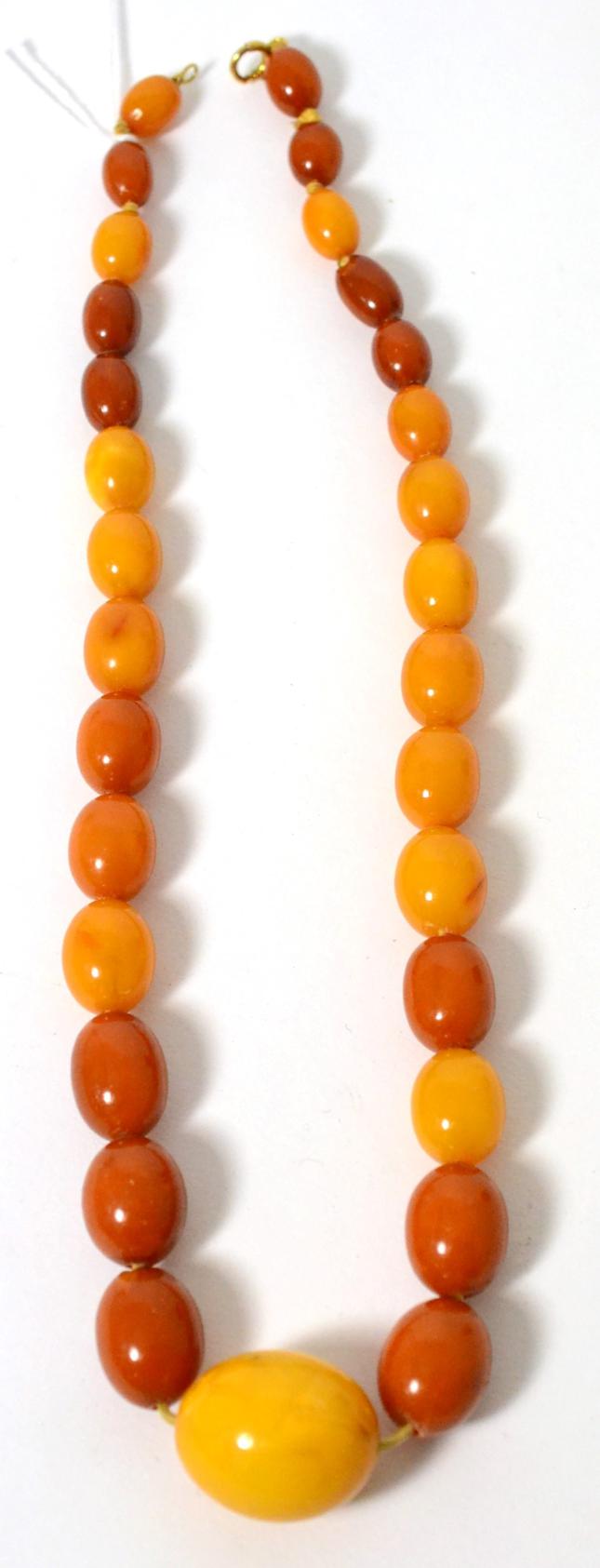 An amber bead necklace, graduated oval amber beads knotted to a bolt ring clasp, length 53.5cm, 57.