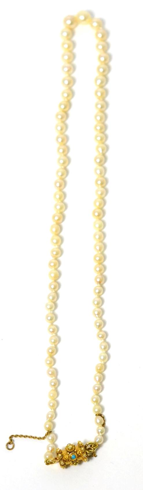 A cultured pearl necklace, a single strand of graduated cultured pearls, knotted to a barrel