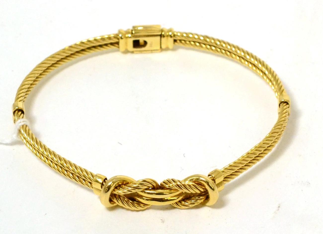 A fancy rope and knot design bangle, stamped '750' 34.13g gross