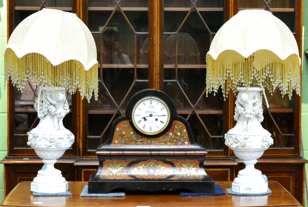 A pair of decorative white glazed table lamps decorated with putti