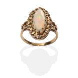 An Arts & Crafts Opal Ring, an oval opal in a claw setting within a border of small flower heads, to