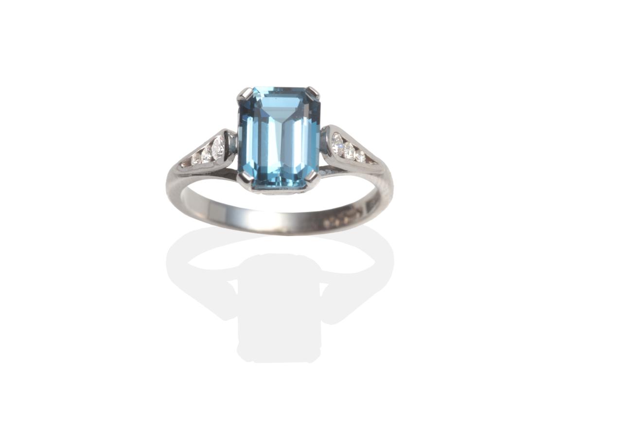 An 18 Carat White Gold Blue Topaz and Diamond Ring, an octagonal cut blue topaz in a claw setting to