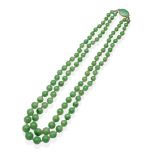 A Jade Necklace, a double strand of graduated jade beads knotted to a jade set oval clasp,