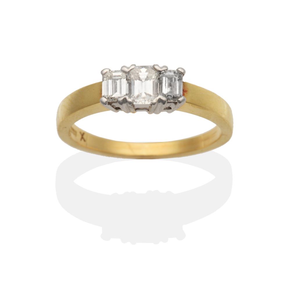 An 18 Carat Diamond Three Stone Ring, graduated octagonal cut diamonds in claw settings, on a flat