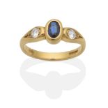 An 18 Carat Gold Sapphire and Diamond Three Stone Ring, an oval cut sapphire in a rubbed over