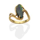 An 18 Carat Gold Black Opal Ring, an abstract oval black opal to scroll twist shoulders, finger size