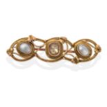 An Arts & Crafts Citrine and Mother-of-Pearl Brooch, an oval cut citrine between two mother-of-pearl