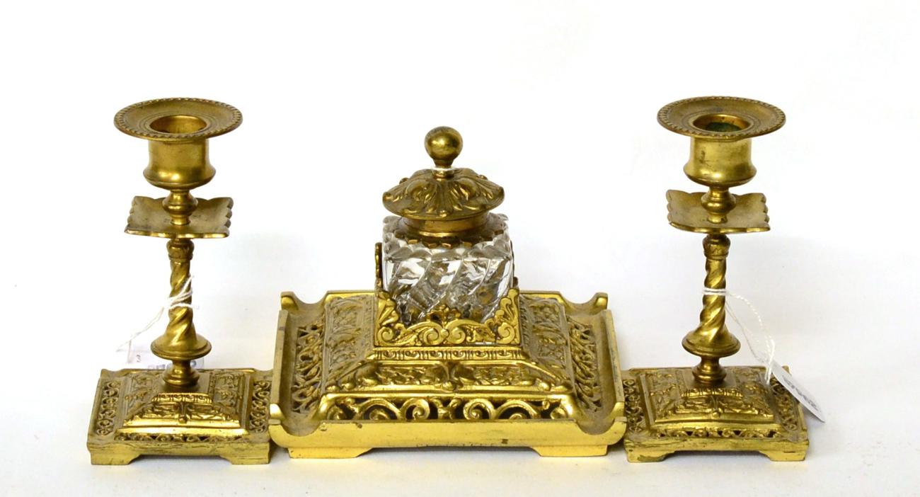 A three piece gilt brass desk set comprising inkwell with a pair of candlesticks (3)