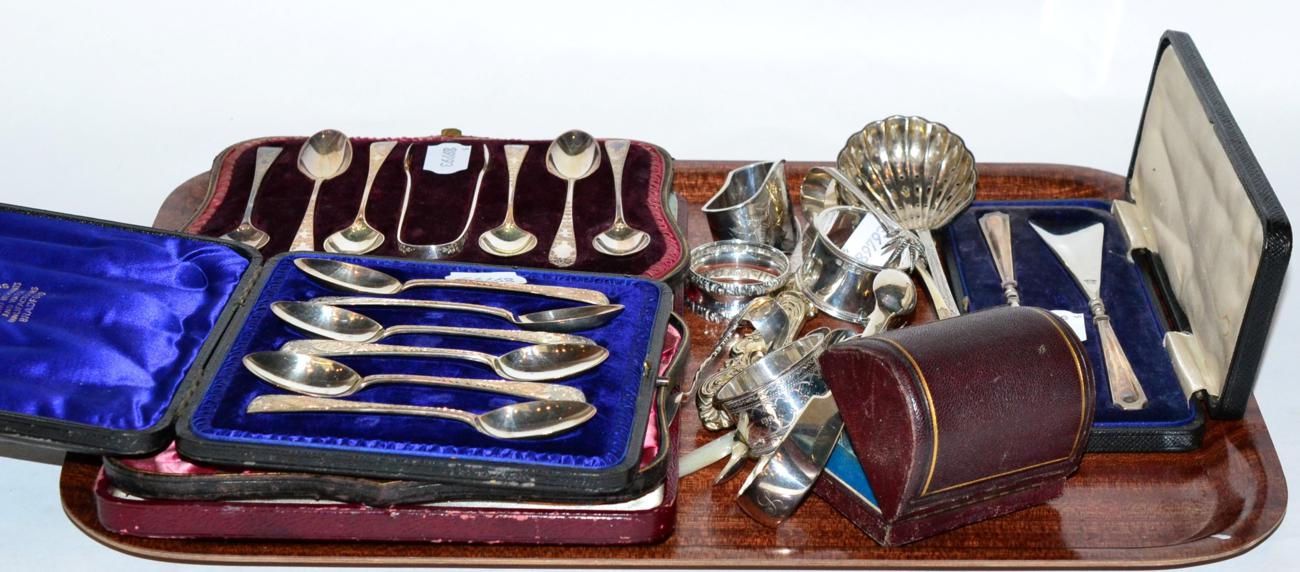 Two cased sets of silver teaspoons; a cased set of butter knives; a group of assorted napkin