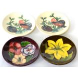 Moorcroft pottery group of four coasters including Finch and Berry pattern