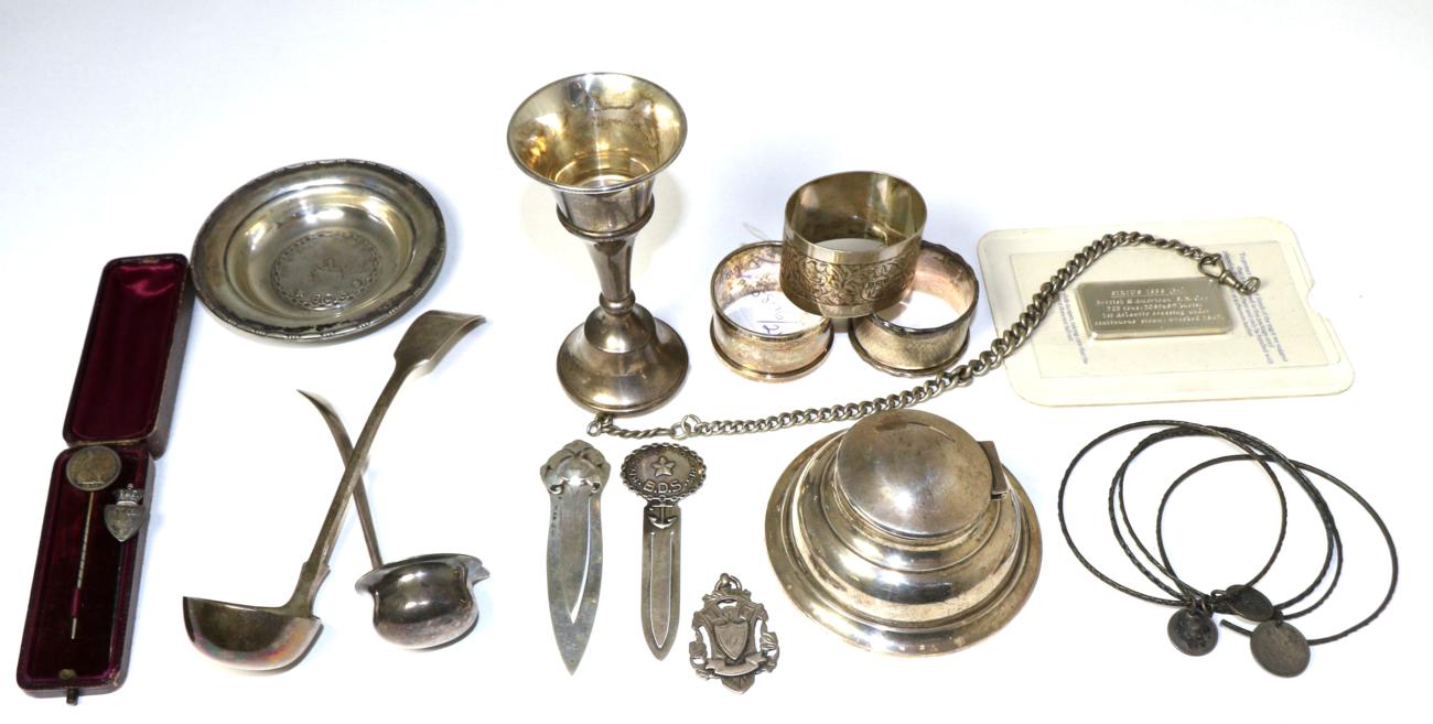 A group of assorted silver items to include: five commemorative silver 1oz ingots; a capstan