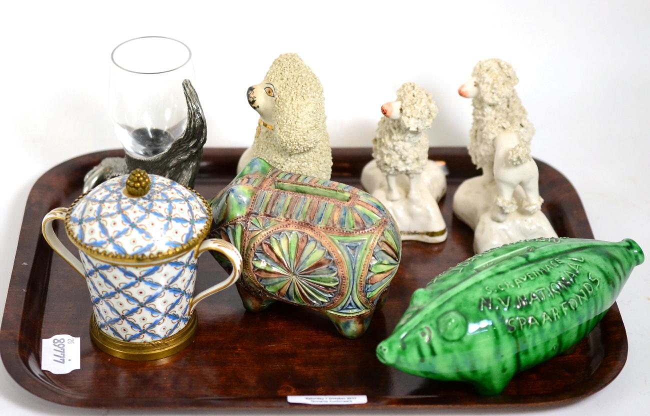 A Serves porcelain cup and cover, three Staffordshire poodles, two pottery piggy banks, etc