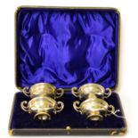 A set of four silver twin-handled salts, in a fitted case