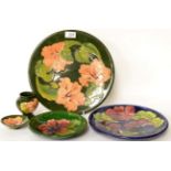 Five pieces of Walter Moorcroft pottery including coral Hibiscus, Clematis, and standard Hibiscus (
