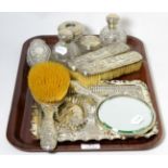 A silver dressing table set including tray, decorated with putti, together with other dressing table
