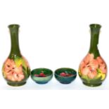 A pair of Walter Moorcroft Coral Hibiscus vases, on green grounds, and two Walter Moorcroft Hibiscus