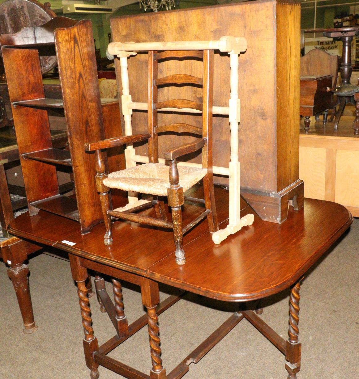A 1920's oak gateleg dining table, an open bookcase of similar date, a child's Lancashire style