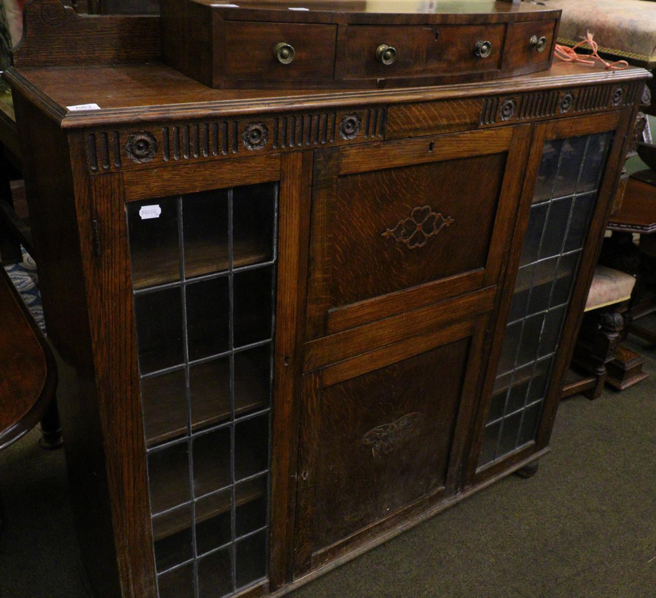 A 1920's oak cabinet with twin leaded glass doors