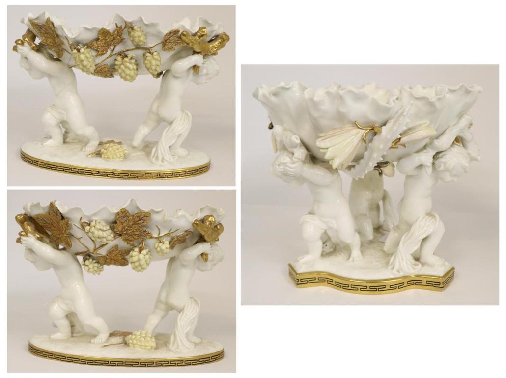 A Moore Glazed Parian Three Piece Garniture, circa 1880, modelled as shells supported by putti on