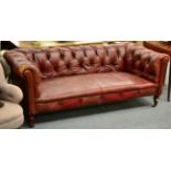 A Victorian Chesterfield Sofa, 3rd quarter 19th century, covered in worn maroon leather, raised on