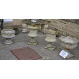 A Pair of Weathered Composition Garden Urns, of campana shaped form decorated with leaves, with