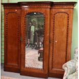 ~ A Victorian Mahogany Triple Door Wardrobe, circa 1870, with a moulded cornice above two cupboard