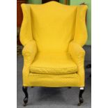 A Victorian Wing-Back Chair, late 19th century, upholstered in yellow floral fabric, with flared
