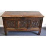 A 17th Century Joined Oak Chest, the hinged lid above three carved panels all between carved