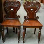 ~ A Pair of Victorian Mahogany Hall Chairs, mid 19th century, with scrolled back supports centred by