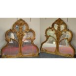 A Pair of Carved Gilt and Gesso Mirrors, with stylised scrolls headed by acanthus and floral plumes,