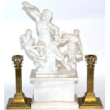 An alabaster figure group of Laocoön and his sons, a plinth base and two brass candlesticks