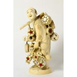 A Japanese Ivory Okimono, Meiji period (1868-1912), as a drum seller carrying drums suspended from a