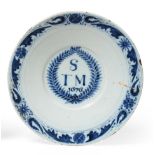 An English Delft Marriage Plate, dated 1676, the central well painted in blue with S/TM 1676