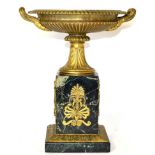 A Gilt Bronze Tazza, in Empire style, with gadrooned borders and fluted handles, on a circular socle
