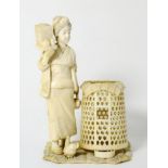 A Japanese Ivory Okimono, Meiji period (1868-1912), as a girl standing holding boxes, a chicken at