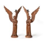 A Pair of Carved Oak Altar Angels Candlesticks, adzed all over, both holding the rod for the candle,