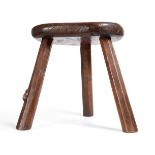 Mouseman: A Robert Thompson English Oak Cow Stool, the solid dished top on three octagonal legs,