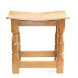 Mouseman: A Robert Thompson English Oak Dish Topped Stool, the top on four octagonal legs joined