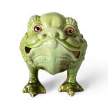 A Burmantofts Faience Pottery Grotesque Toad, modelled on three legs with glass eyes, green glaze,