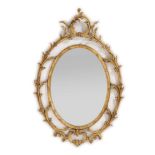 A George III Style Carved Giltwood Mirror, the oval plate with an acanthus frame and C scroll