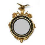 A Regency Carved Giltwood and Gesso Convex Mirror, early 19th century, with an ebonised slip