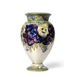 William Moorcroft (British, 1872-1945): A Pansy Pattern Pedestal Vase, circa 1913-16, in purple,