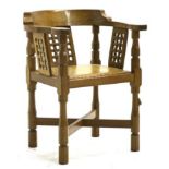 Mouseman: A Robert Thompson Oak Monk's Chair, with curved back and shaped arms, over three lattice